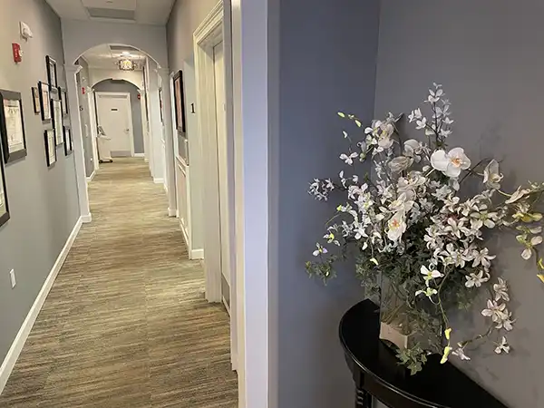 Hallway with corner table and beautiful flowers at Artistic Dental in Jackson, NJ