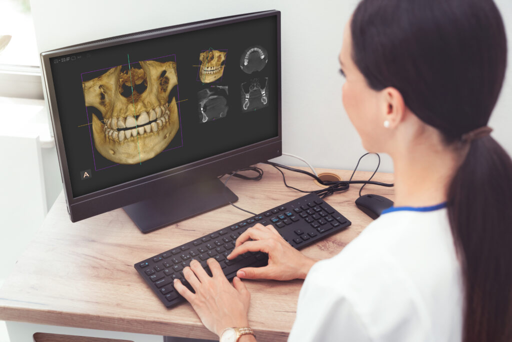 Woman dentist is looking at a photo of the 3D tomograph. Treatment, protection, health care for teeth