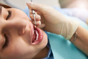 Dentist examining patient during full mouth reconstruction consultation