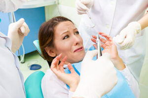 Anxious female dental patient sitting in dentist office chair
